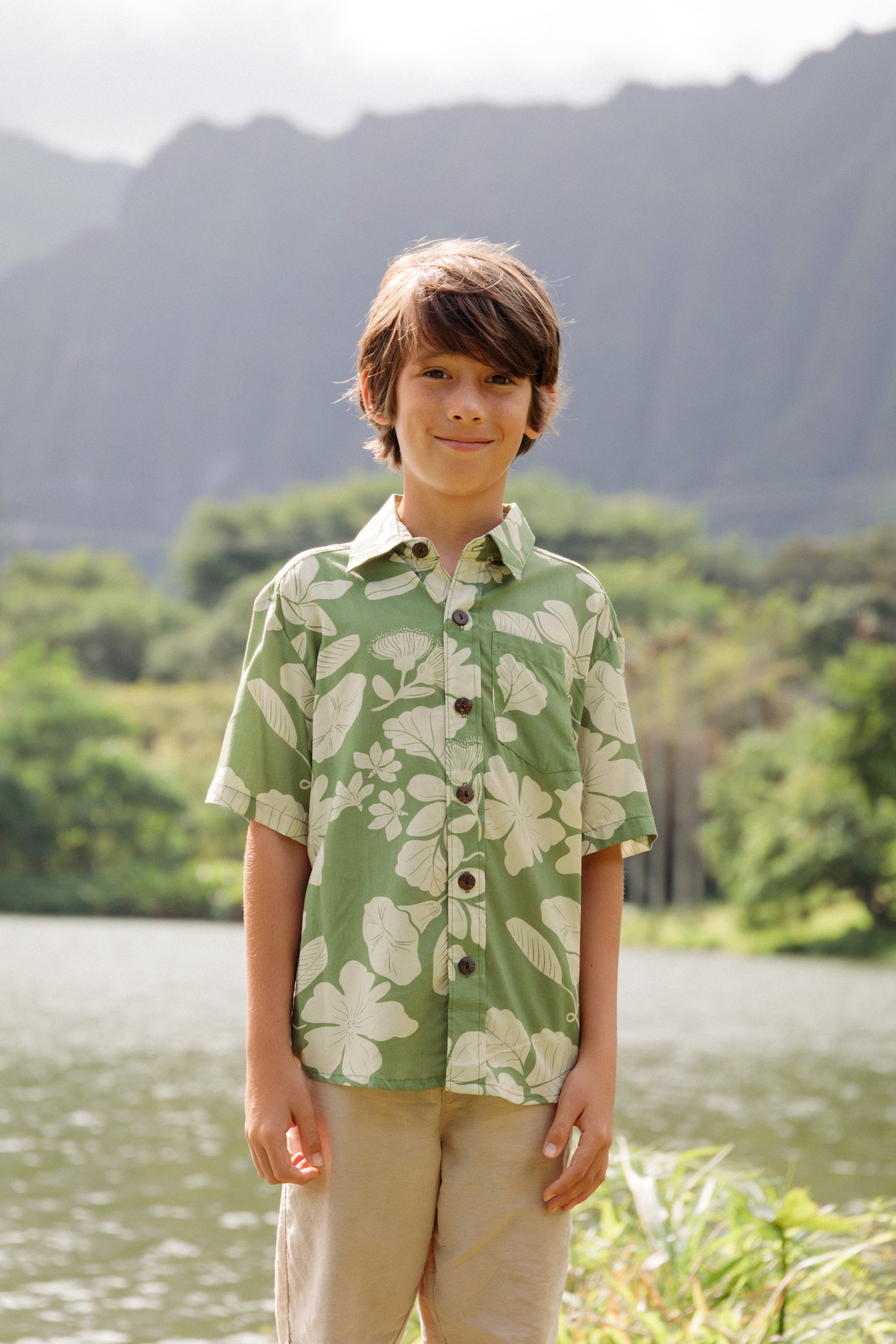 little boy wearing green aloha shirt with native Hawaiian plants