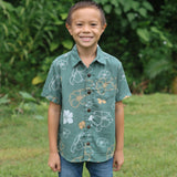 little boy wearing lush green aloha button up shirt with pua kenikeni print