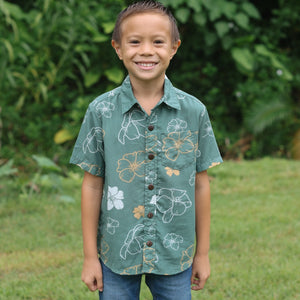little boy wearing lush green aloha button up shirt with pua kenikeni print