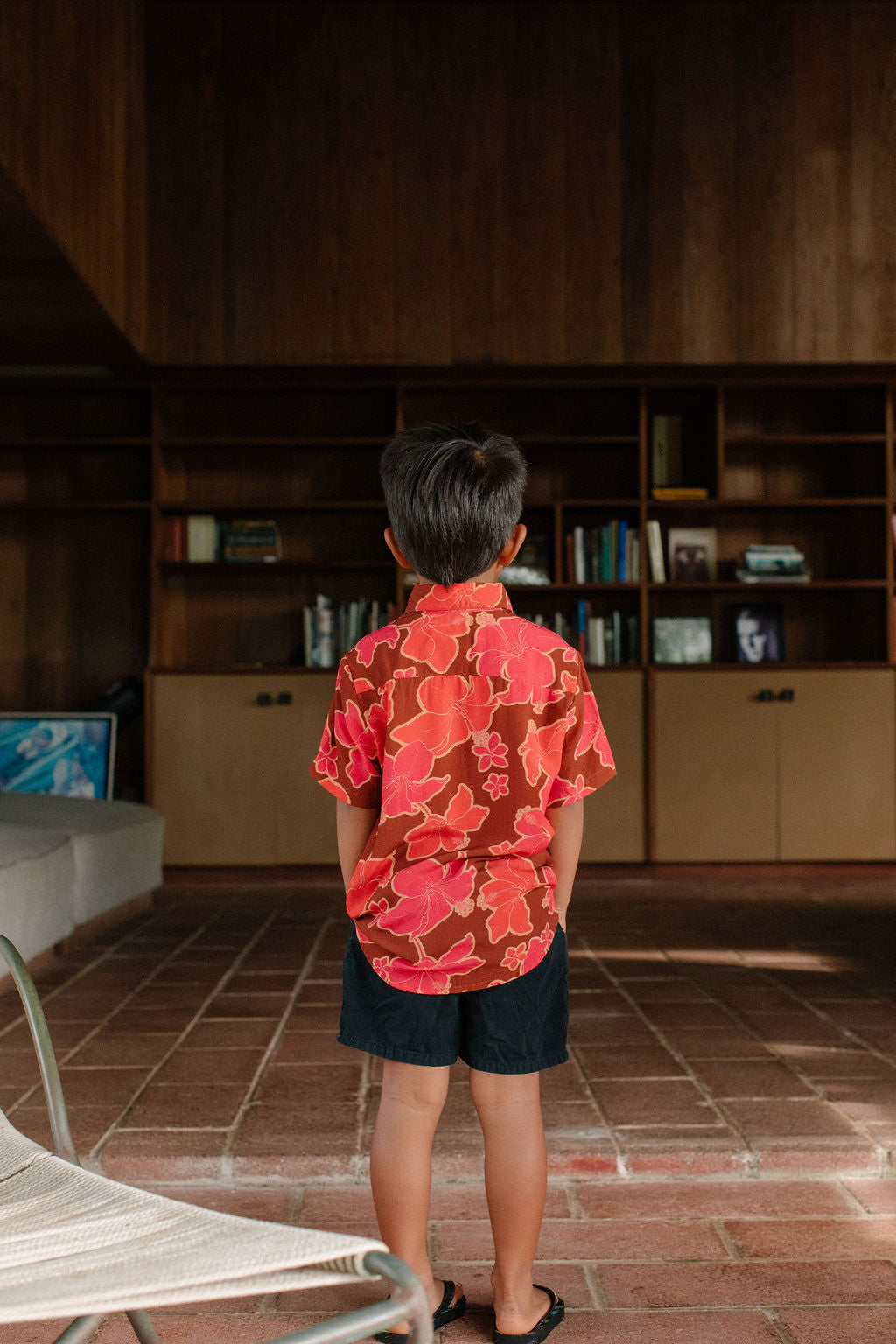 litte boy wearing aloha button up shirt with vibrant pink pua pattern