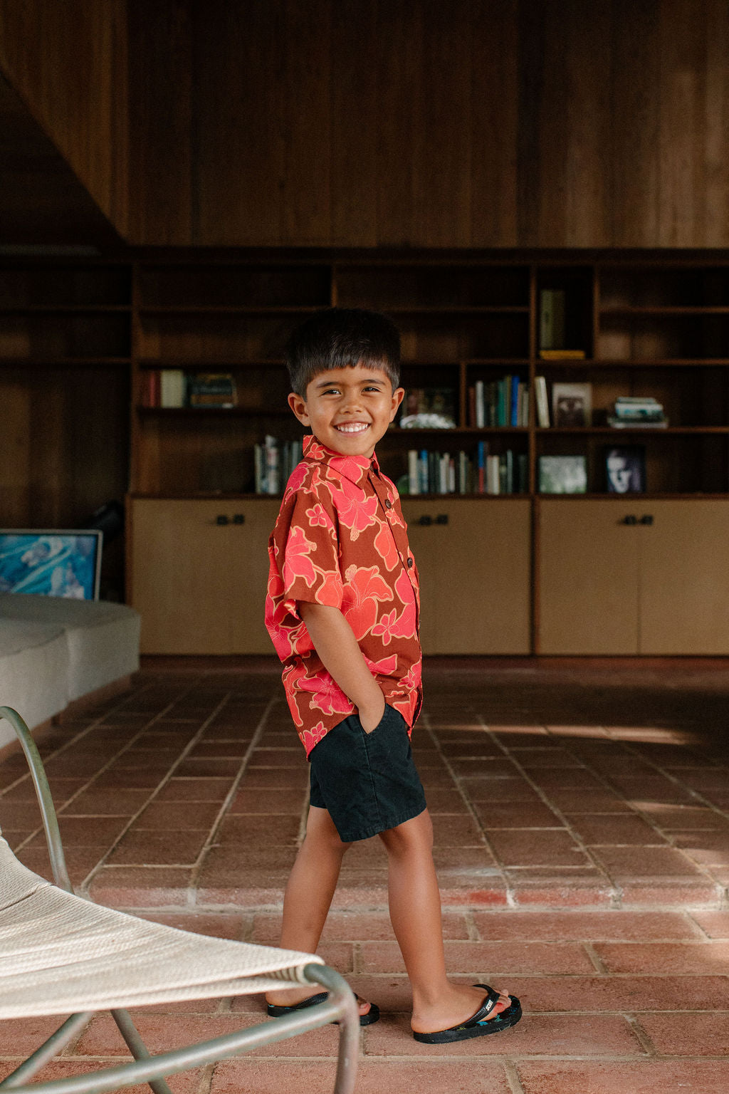 litte boy wearing aloha button up shirt with vibrant pink pua pattern
