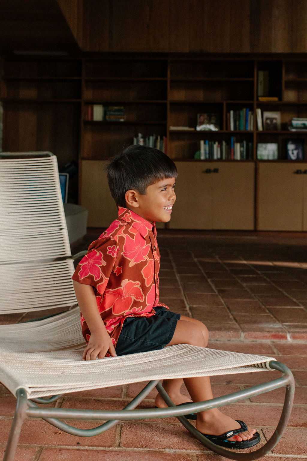litte boy wearing aloha button up shirt with vibrant pink pua pattern