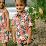 little boy wearing an aloha button up shirt with red ginger and tiare print