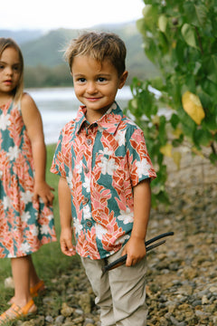 little boy wearing an aloha button up shirt with red ginger and tiare print