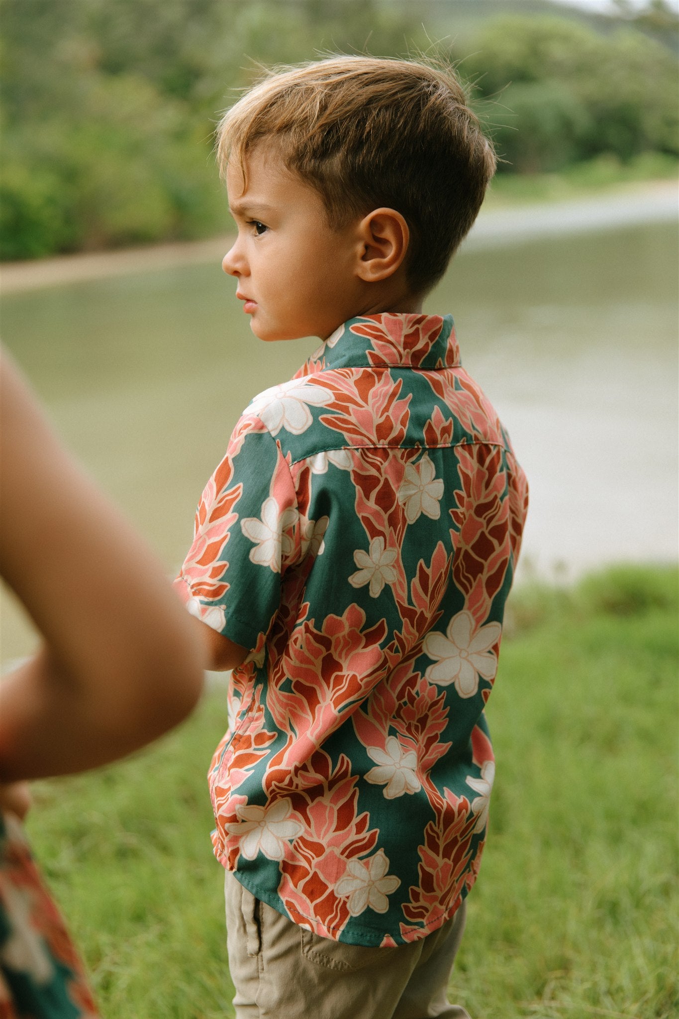little boy wearing an aloha button up shirt with red ginger and tiare print