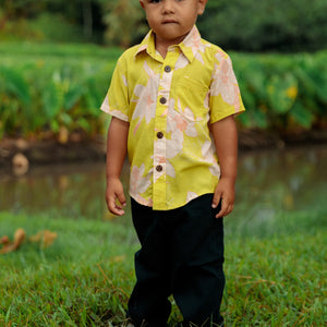 little boy wearing bright green aloha shirt with orchid print