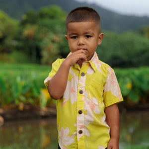 little boy wearing bright green aloha shirt with orchid print