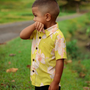 little boy wearing bright green aloha shirt with orchid print