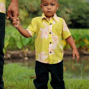 little boy wearing bright green aloha shirt with orchid print
