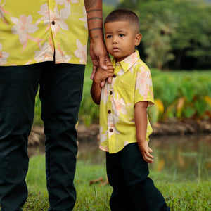 little boy wearing bright green aloha shirt with orchid print
