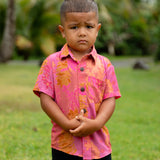 little boy wearing a mini aloha button up shirt in pink with lei pattern
