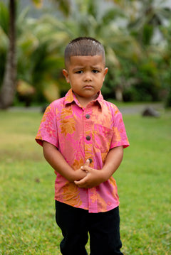 little boy wearing a mini aloha button up shirt in pink with lei pattern