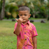 little boy wearing a mini aloha button up shirt in pink with lei pattern