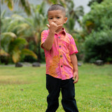 little boy wearing a mini aloha button up shirt in pink with lei pattern