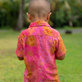 little boy wearing a mini aloha button up shirt in pink with lei pattern