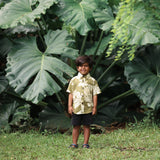 little boy wearing mini aloha button up shirt in green print and naupaka pattern