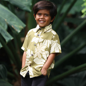 little boy wearing mini aloha button up shirt in green print and naupaka pattern