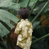 little boy wearing mini aloha button up shirt in green print and naupaka pattern