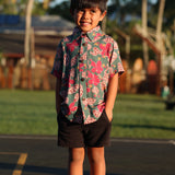 little boy wearing a teal aloha shirt with shell and pua print 