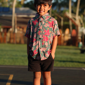 little boy wearing a teal aloha shirt with shell and pua print 