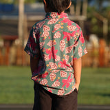 little boy wearing a teal aloha shirt with shell and pua print 