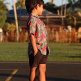little boy wearing a teal aloha shirt with shell and pua print 