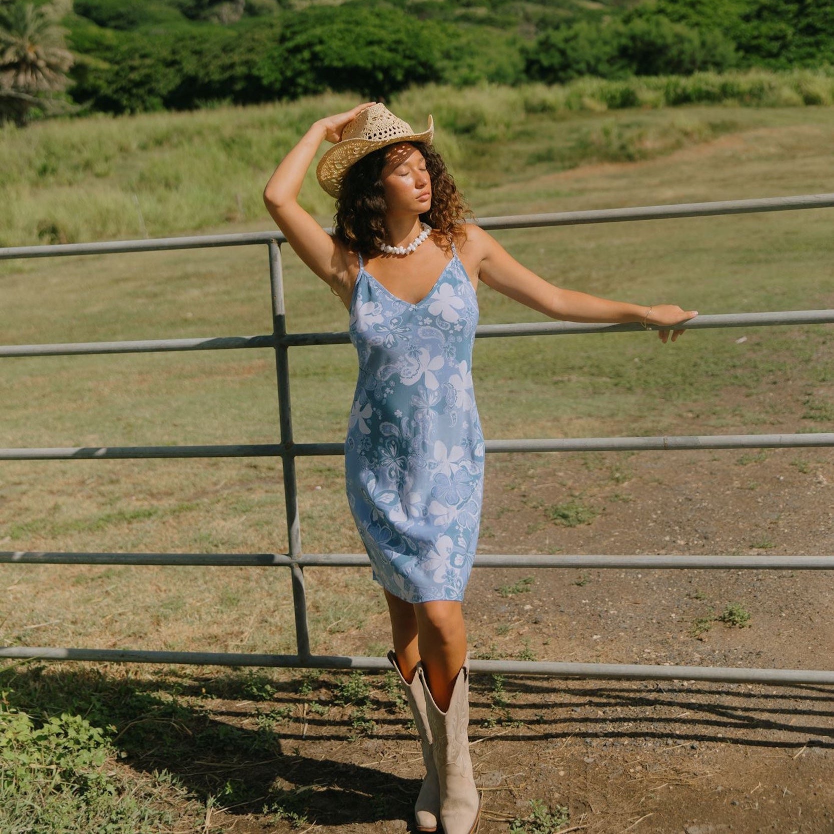 woman with brown hair wearing blue paisley printed slip dress