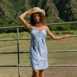 woman with brown hair wearing blue paisley printed slip dress