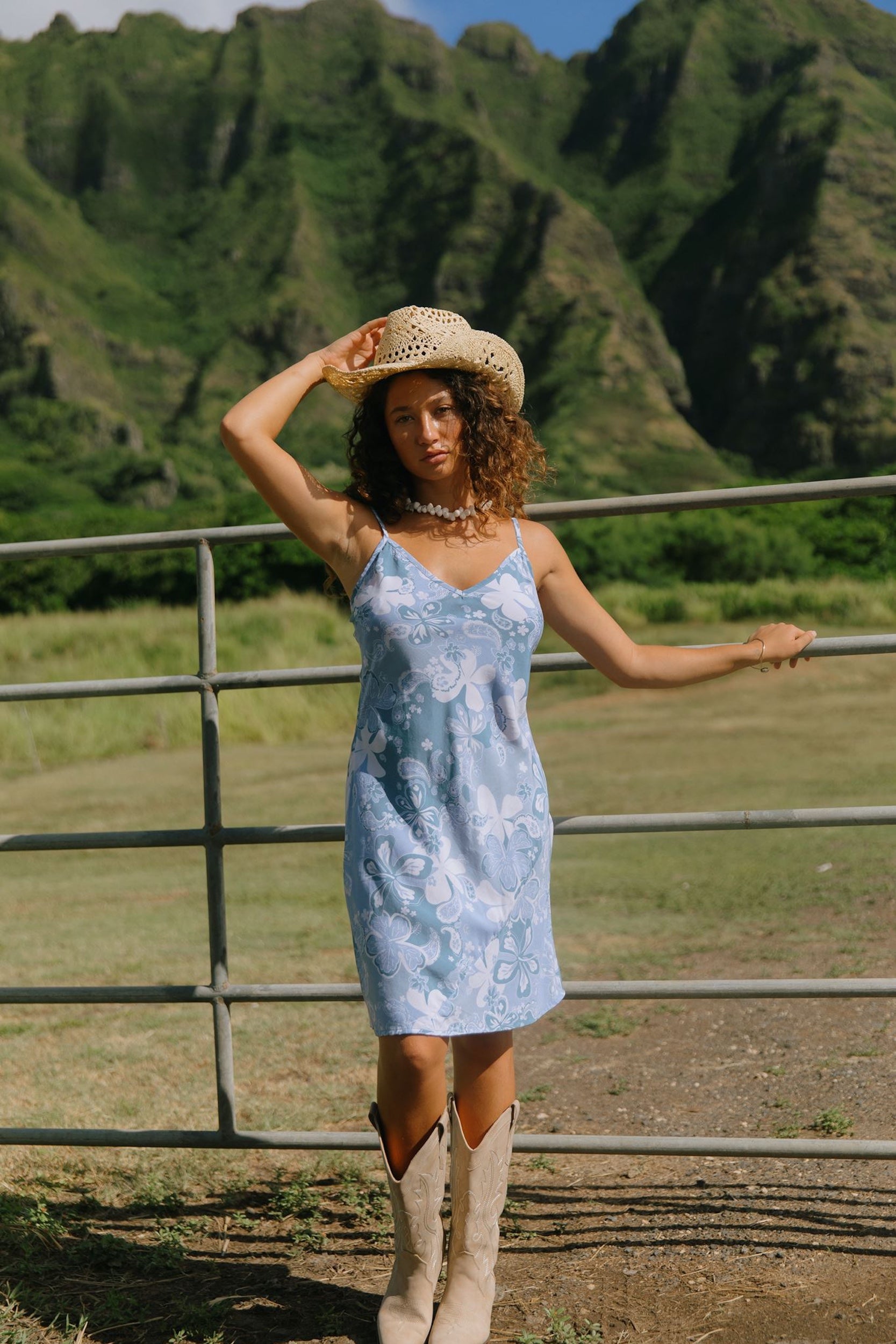 woman with brown hair wearing blue paisley printed slip dress