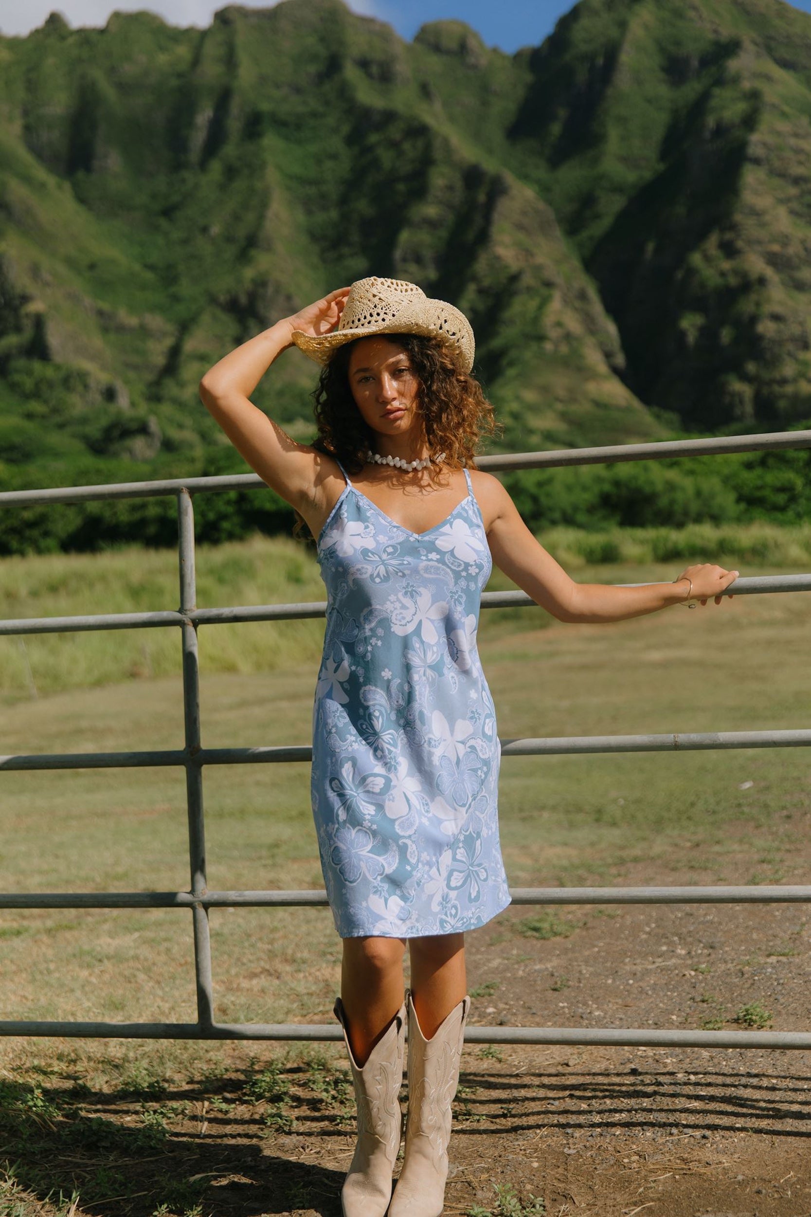 woman with brown hair wearing blue paisley printed slip dress