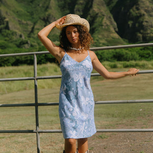 woman with brown hair wearing blue paisley printed slip dress