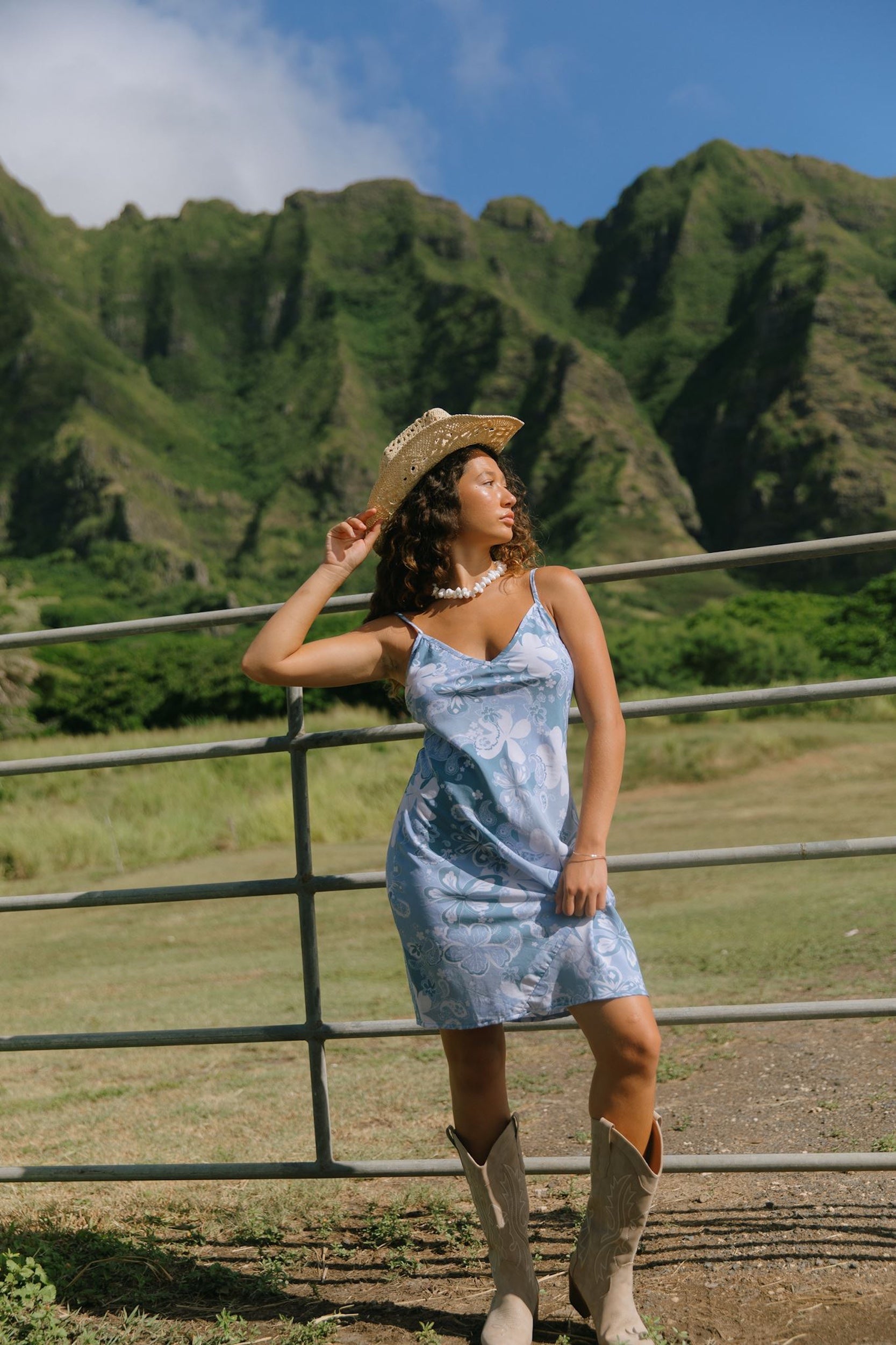 woman with brown hair wearing blue paisley printed slip dress