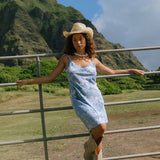 woman with brown hair wearing blue paisley printed slip dress