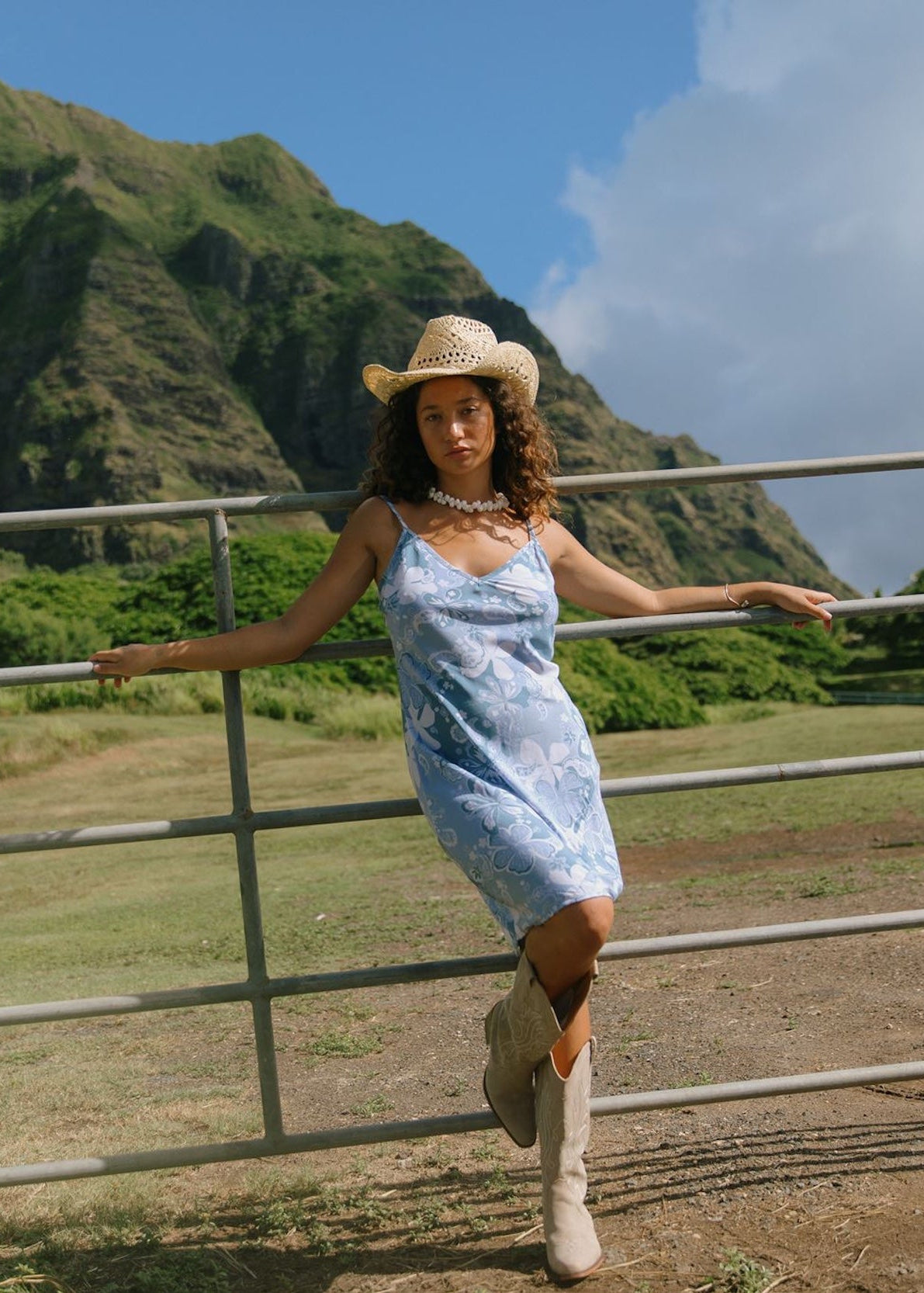 woman with brown hair wearing blue paisley printed slip dress