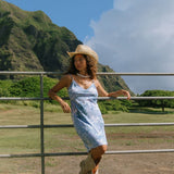 woman with brown hair wearing blue paisley printed slip dress