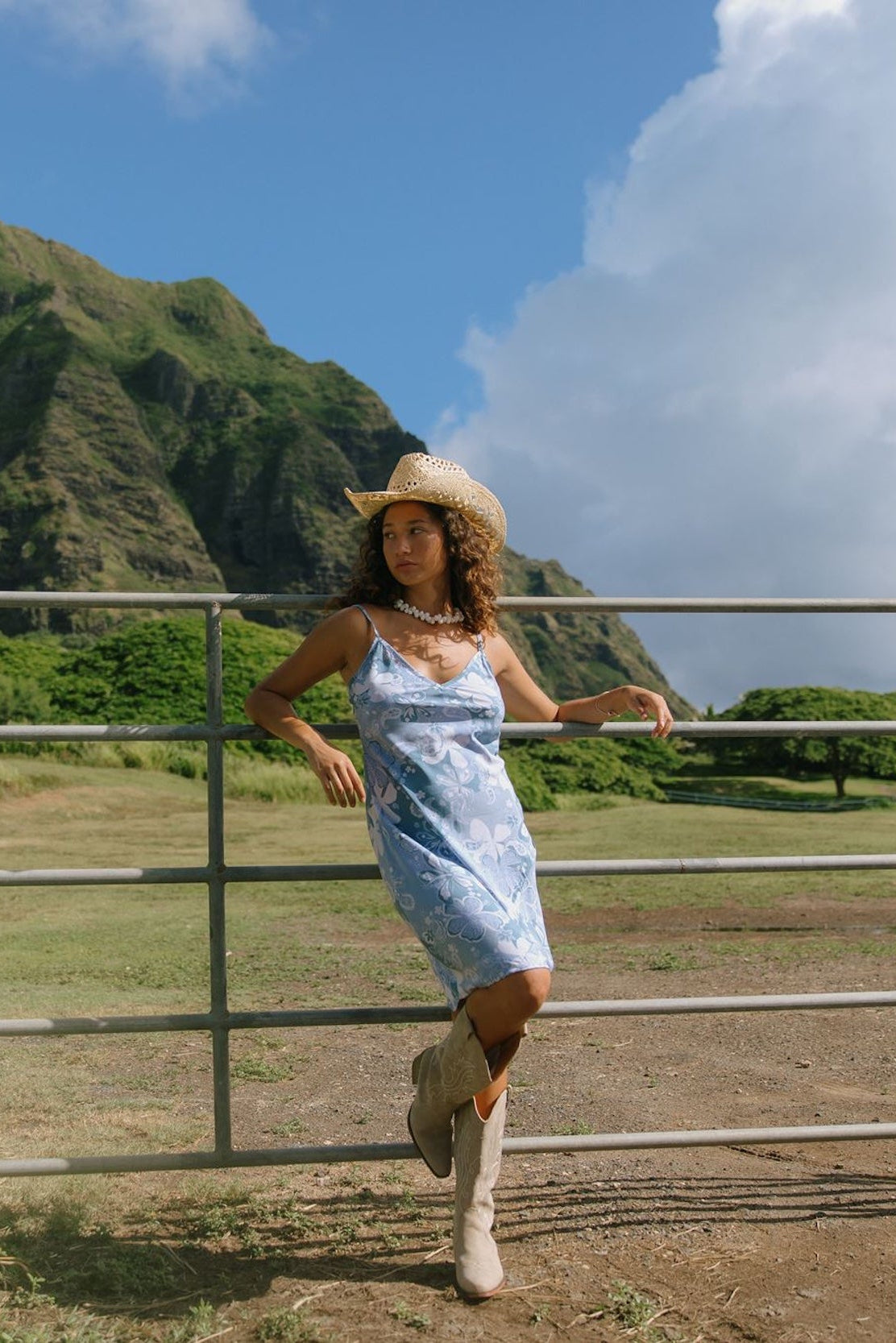 woman with brown hair wearing blue paisley printed slip dress