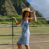 woman with brown hair wearing blue paisley printed slip dress