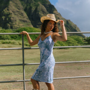 woman with brown hair wearing blue paisley printed slip dress