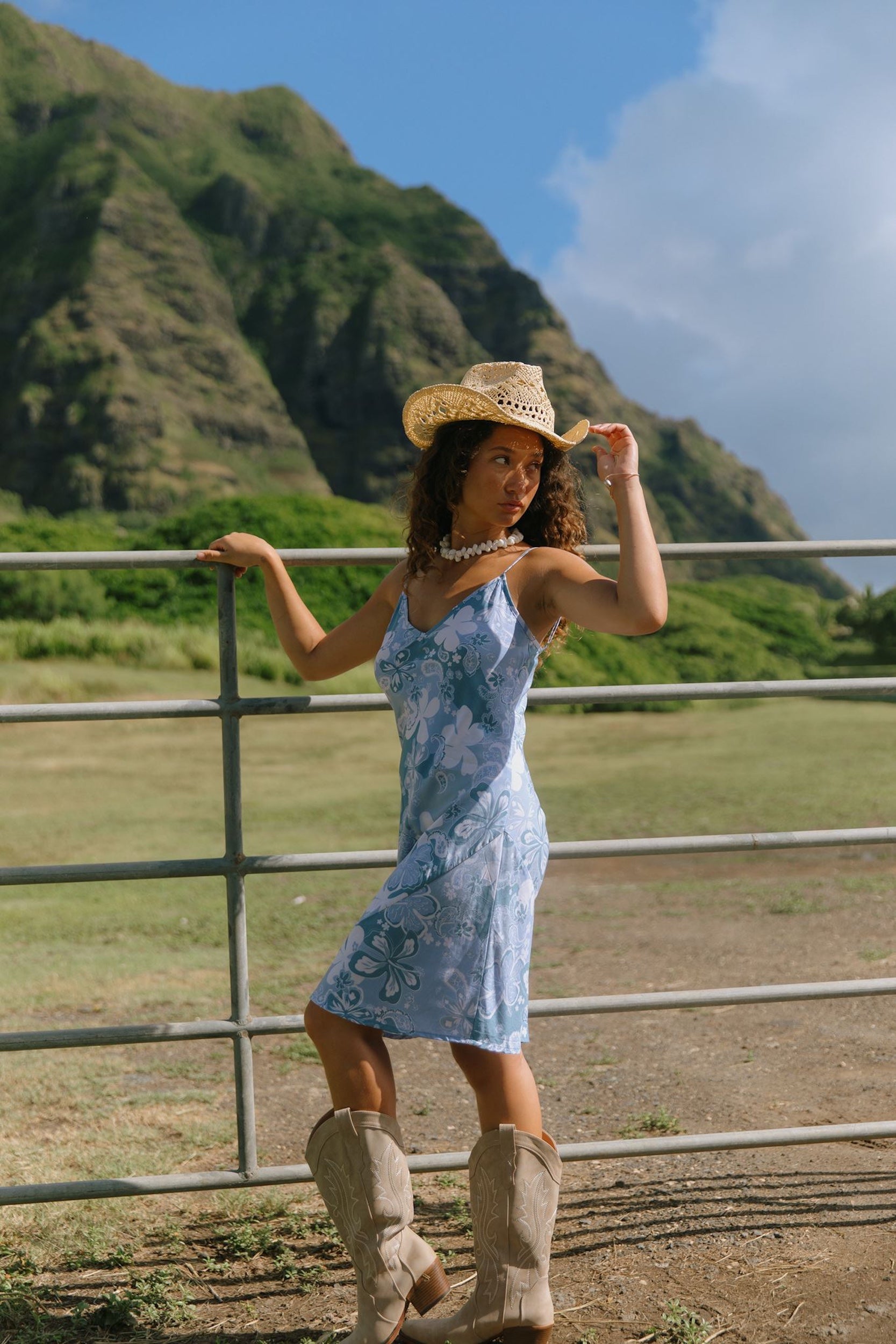 woman with brown hair wearing blue paisley printed slip dress