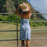 woman with brown hair wearing blue paisley printed slip dress
