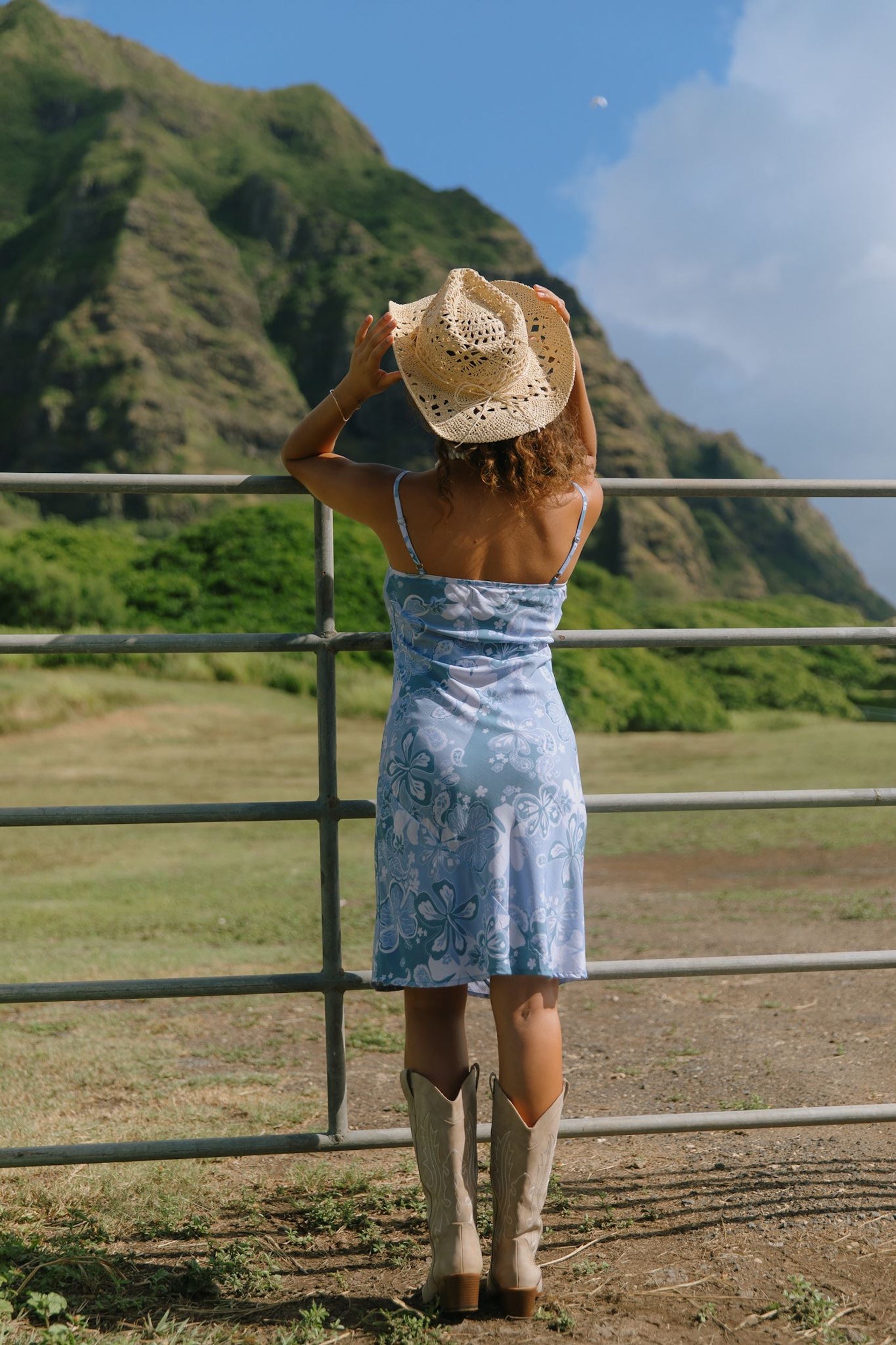 woman with brown hair wearing blue paisley printed slip dress