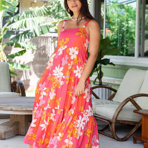 woman with brown hair wearing a pink maxi thin strap dress with retro flower print 
