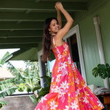 woman with brown hair wearing a pink maxi thin strap dress with retro flower print 