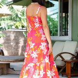woman with brown hair wearing a pink maxi thin strap dress with retro flower print 
