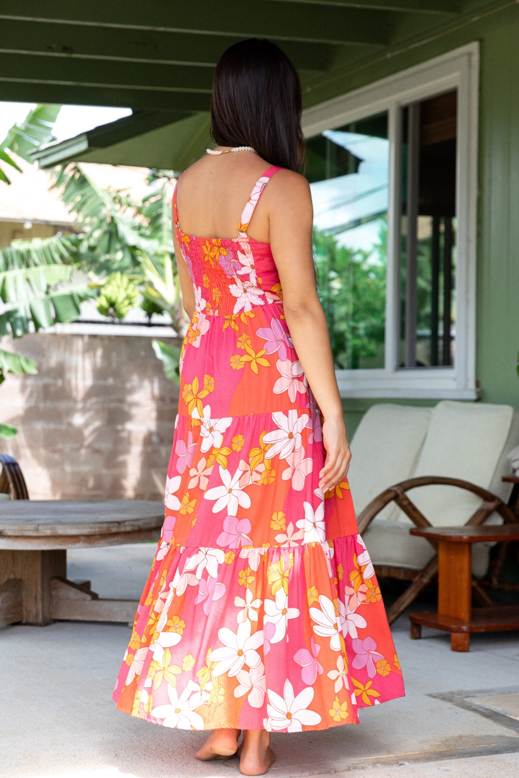 woman with brown hair wearing a pink maxi thin strap dress with retro flower print 