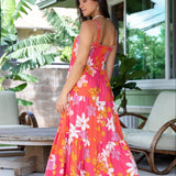 woman with brown hair wearing a pink maxi thin strap dress with retro flower print 