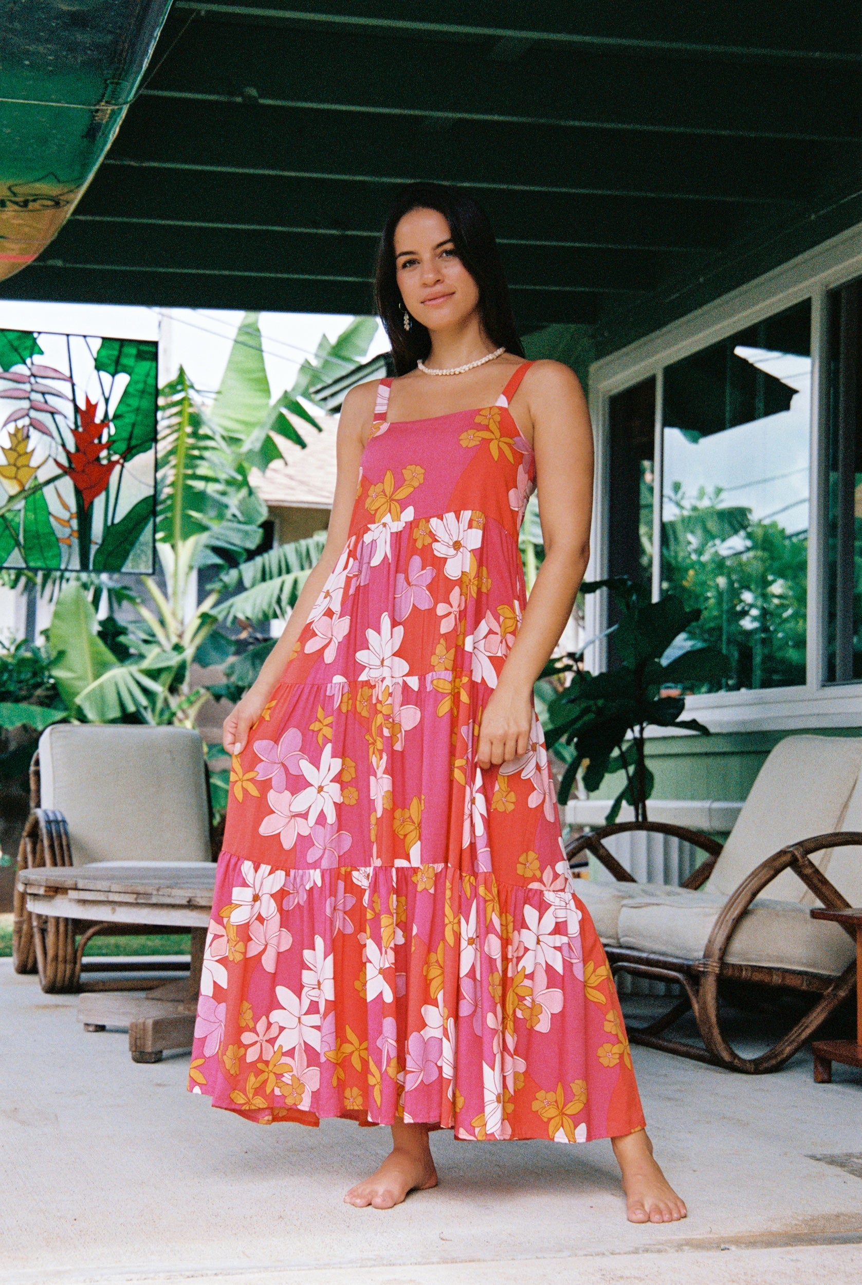 woman with brown hair wearing a pink maxi thin strap dress with retro flower print 