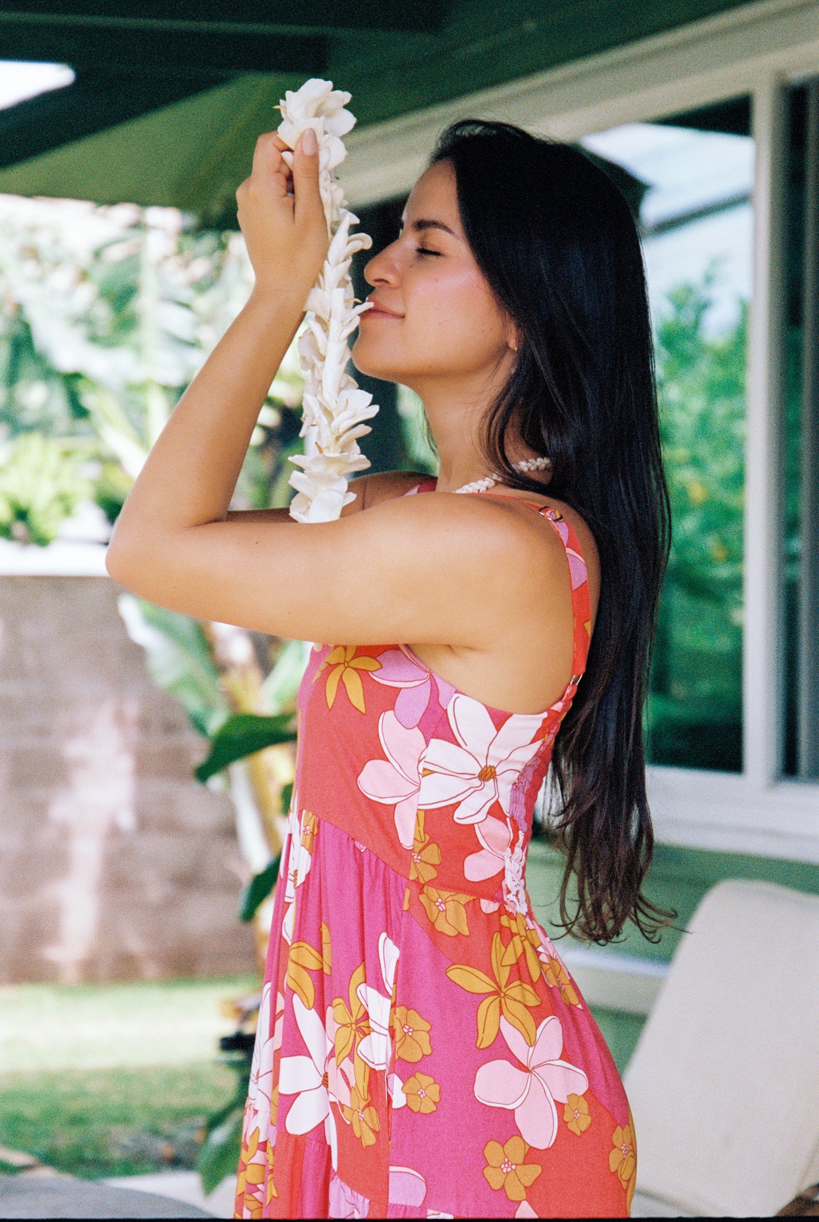 woman with brown hair wearing a pink maxi thin strap dress with retro flower print 