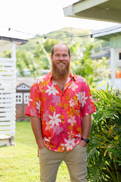 man wearing pink aloha button up shirt with retro flower pattern
