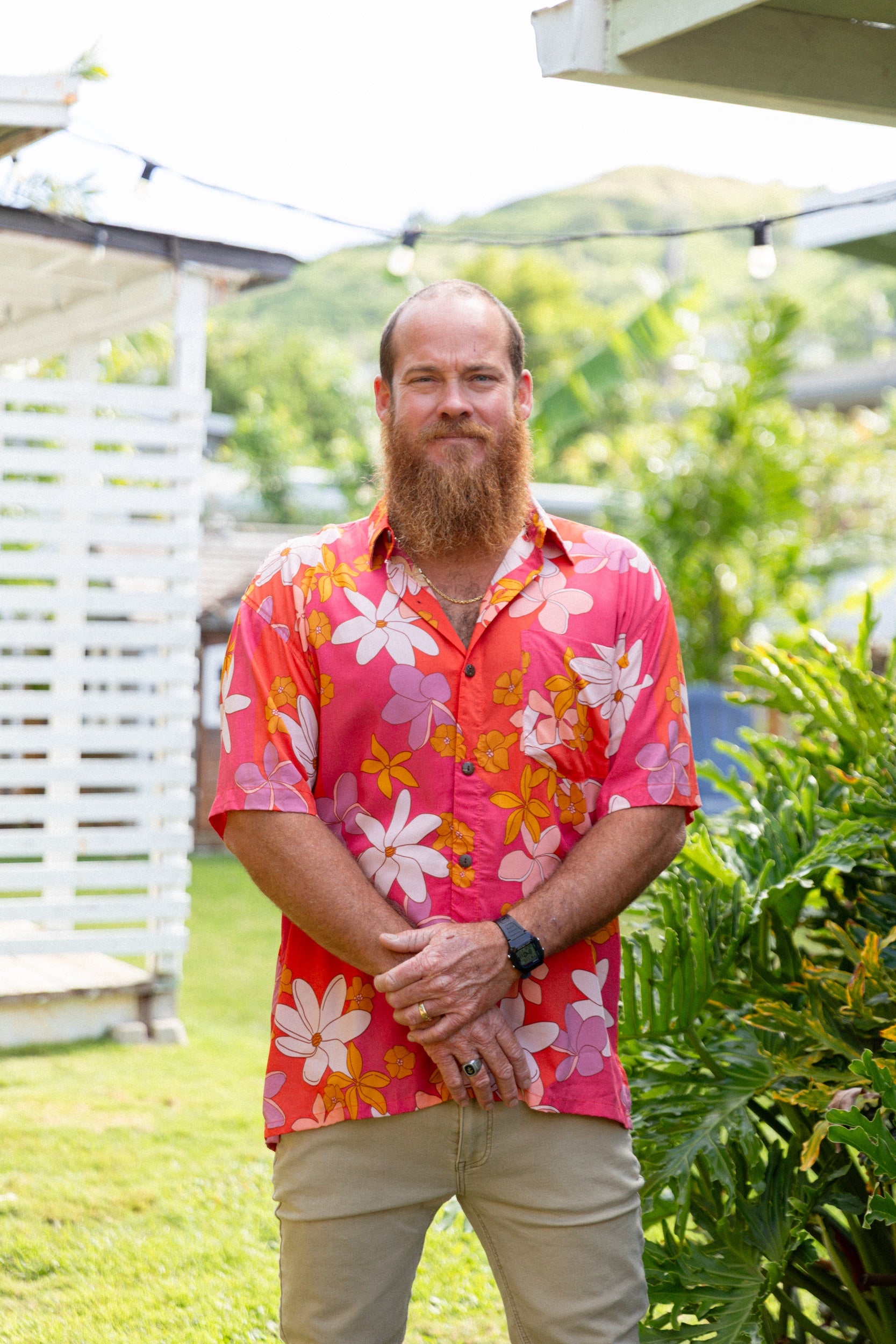 man wearing pink aloha button up shirt with retro flower pattern